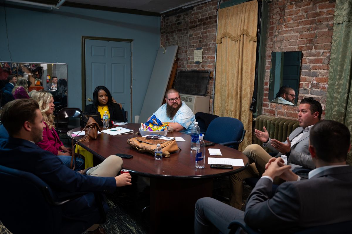 Individuals sitting around a table discussing.